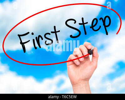 Mann Hand schreiben Erster Schritt mit schwarzem Marker auf visuelle Bildschirm Stockfoto