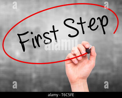 Mann Hand schreiben Erster Schritt mit schwarzem Marker auf visuelle Bildschirm Stockfoto