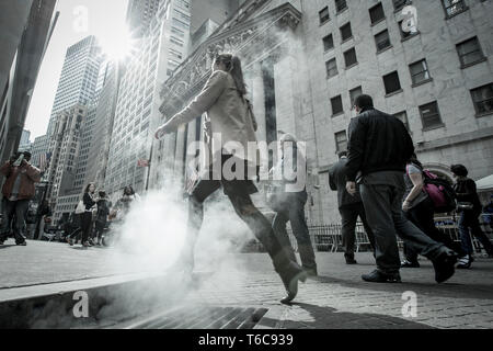 Dampf tritt aus dem steampipes Bereitstellung der Generator für Bürogebäude in New York. Die Menschen sind, die durch den Dampf, wie Sie vorbei vor der NYSE Euronext Börse an der Wall Street sind. Stockfoto