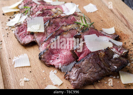 Traditionelle italienische Tagliata Steak mit Parmesan als Close-up auf Schneidebrett Stockfoto