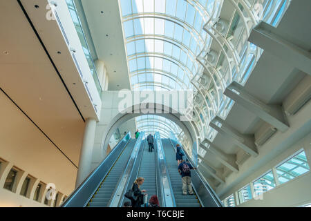Leute, Fahrt mit der Rolltreppe am San Diego Convention Center in der Innenstadt von San Diego, Kalifornien, USA an einem sonnigen Tag. Stockfoto