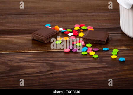 Bunten Streuseln und Schokolade Stücke auf Holz- Hintergrund mit kopieren. Stockfoto