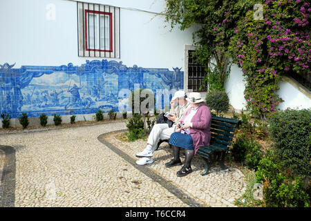 Touristen, die auf der Suche an einem historischen Darstellung der Belagerung von Lissabon 1147 in Blau Wandfliesen gedacht Azulejos in Alfama Lisboa Portugal KATHY DEWITT Stockfoto