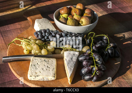 Holz- Plateau mit Trauben und Käse Stockfoto