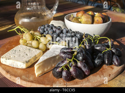 Holz- Plateau mit Trauben und Käse Stockfoto