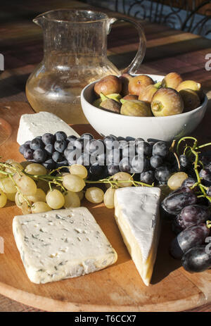 Holz- Plateau mit Trauben und Käse Stockfoto