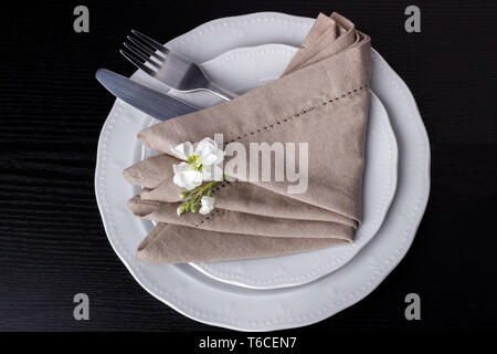 Teller mit Gabel, Messer und Serviette auf hölzernen Tisch Stockfoto