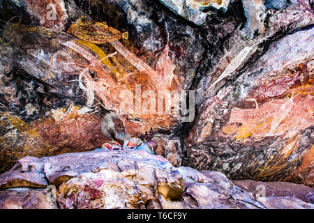 Einheimischer Guide erklärt Aborigine Rock Kunst in Long Tom Träumen, Gunbalanya, Australien Stockfoto