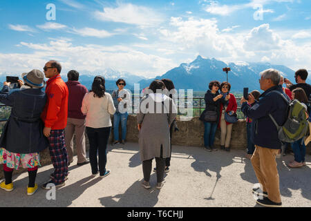 Chinesische Touristen in Europa, einer Chinesischen Reisegruppe die alpine Landschaft aus dem Salzburger Schloss Aussichtsterrasse, Österreich. Stockfoto