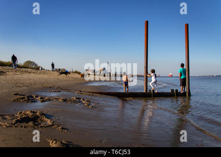 STADE / HAMBURG, DEUTSCHLAND - Oktober 16, 2017: Die Menschen sind mit einem ungewöhnlich warmen Tag an einem Strand der Elbe in der Nähe von Stade/Hamburg in Norddeutschland Stockfoto