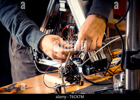 Zwei männliche Meister Arbeiten in der Werkstatt mit Elektronik, Kabel, 3d-Drucker Stockfoto