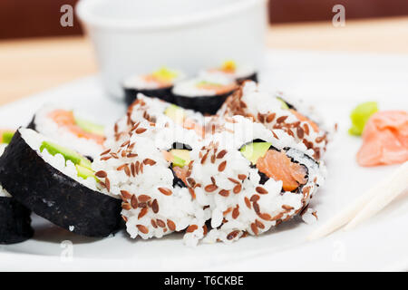 Sushi mit Lachs, Avocado, Reis in Seetang serviert mit Wasabi und Ingwer. Stockfoto