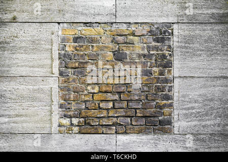 gelbe Mauer umrahmt von Granitplatten Stockfoto