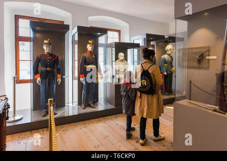 Mutter Kind Museum, Rückansicht eines Elternteils und Tochter besuchen eine Ausstellung der Österreichischen militärischen Uniformen Im Salzburg Museum, Österreich. Stockfoto