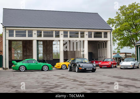 Porsche Autos vor einer Garage im Bicester Heritage Center Drive es Tag. Bicester, Oxfordshire, England Stockfoto