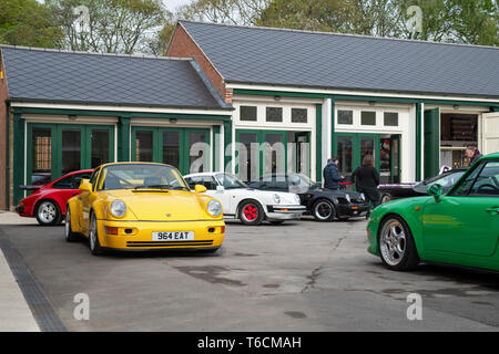 Porsche Autos vor einer Garage im Bicester Heritage Center. Bicester, Oxfordshire, England Stockfoto