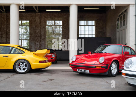 1989 Porsche Carrera Coupe club sport und 1994 Porsche Carrera Autos vor einer Garage im Bicester Heritage Center. Bicester, Oxfordshire, England Stockfoto