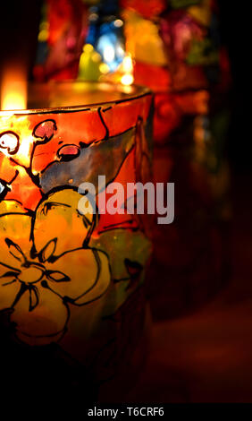 Glas Kerzenhalter bemalten Glasfenster Lacke mit einer brennenden Kerze im Inneren Stockfoto