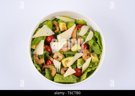 Salat mit Garnelen und Avocado, in weiße Schüssel serviert. Salat mit Garnelen, Avocado, Tomate, Parmesan Stockfoto