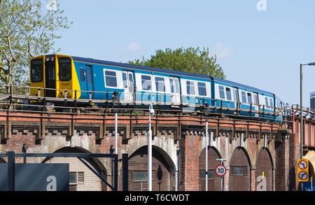 Klasse 313 EWU-Lokomotive (313 201) im Original British Rail Blau & Grau Erbe Livree in Portsmouth, Hampshire, Großbritannien überholt. Zug auf einer Brücke. Stockfoto