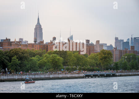 Sonnenuntergang und Boote mit dem East River unter der Brücke am 04.07.2018 zum Unabhängigkeitstag/Sonnenuntergang am East River unter Brücke Stockfoto