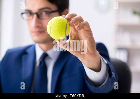 Junge Unternehmer mit Tennis ball Arbeiten im Büro Stockfoto