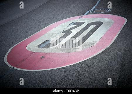 Geschwindigkeitsbegrenzung auf dem Asphalt der Straße in Deutschland Stockfoto