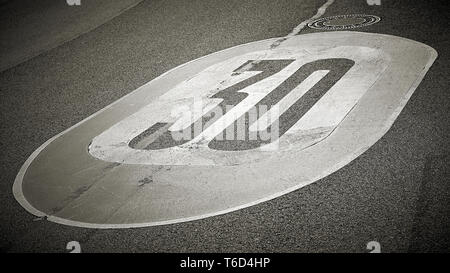 Geschwindigkeitsbegrenzung auf dem Asphalt der Straße in Deutschland Stockfoto