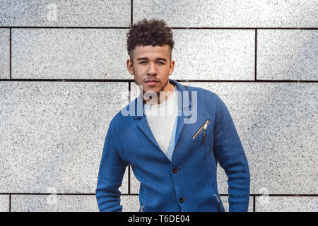 Junge afrikanische amerikanische Mann stand an der Wand, die Kamera sicher in der Nähe isoliert - oben Stockfoto