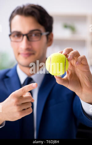 Junge Unternehmer mit Tennis ball Arbeiten im Büro Stockfoto