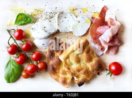 Italienische Antipasti, Käse mocarella, Focaccia, Prosciutto di Parma, Basilikum und Tomaten Stockfoto