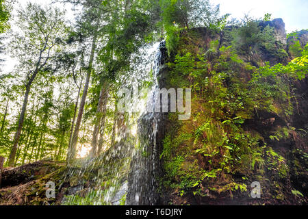 Die Wasserfälle von Menzenschwand, Hochschwarzwald, Deutschland, Cascade in eine Schlucht über rock Kante fallen, Sonnenuntergang hinter dem Wasserfall Stockfoto