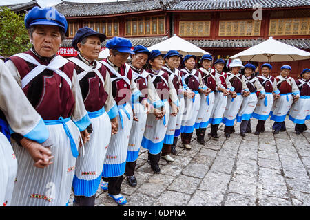 Lijiang, Yunnan, China: eine große Gruppe von Naxi Frauen in den regionalen Kostüm Tanz in einer Reihe am Alten Markt in der Altstadt von Lijiang, Stockfoto