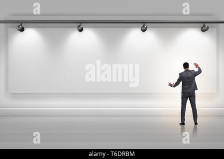 Geschäftsmann drücken virtuelle Taste auf der Wand beleuchtet mit spotlig Stockfoto