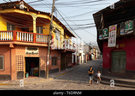 Eine Mutter, die ihr Kind zu Fuß zur Schule - Straßenszene in der Stadt Copan Ruinas, Honduras, Mittelamerika Stockfoto