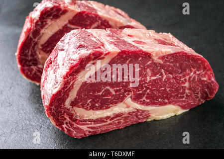 Zwei Rohmaterial trocken im Alter von Kobe Entrecote Steaks als Close-up auf einer Schiefertafel Stockfoto