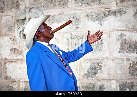 Traditionelle kubanische Mann für Fotos posiert während des Rauchens großen kubanischen Zigarre in der Altstadt von Havanna, Kuba. Stockfoto