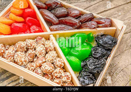 Turkish Delight orientalische Süßigkeiten Trockenfrüchte und Nüsse in einer Holzkiste. Hintergrund. Gesund Vegan essen. Natürliche Lebensmittel. Selektive konzentrieren. Stockfoto