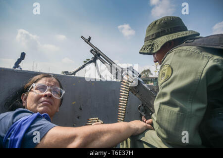 Ein anti Regierung Soldat mit Maschinengewehr die Stelle für den Kampf bereit. Venezolanischen Militärs, die Unterstützung der venezolanischen Opposition leader Juan Guaido sind auf die Strasse mit ihren Waffen zusammen mit der Regierung die Demonstranten in einem Militärputsch gegen die sozialistische Regierung unter der Führung von Präsident Nicolas Maduro. Stockfoto