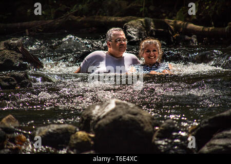 Ein schönes Foto eines glücklichen und msiling Paar sitzen in einem natürlichen heißen Wasser Pool in natürlichen ecotermales in der Nähe von Tabacon, La Fortuna, Costa Rica Stockfoto