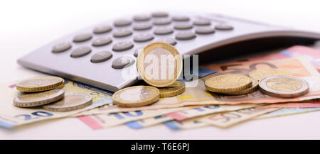 Euro Währung mit Banknoten, Rechner und Münzen Stockfoto