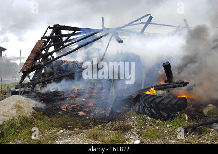 Feuerwehrmann im Einsatz bei brennendem Bauernhaus in Deutschland Stockfoto