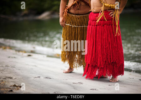 Zwei Männer tragen traditionelle Röcke an einem Strand. Stockfoto