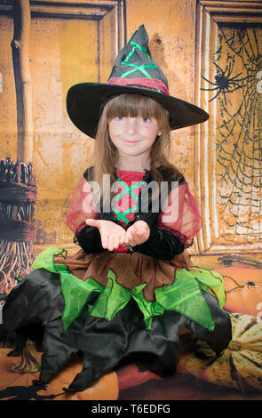 Kleines Mädchen fein angezogen für Halloween. Auf einer Halloween Hintergrund. Stockfoto