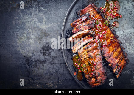 Grill Schweinerippchen mit Obst genießen, wie es oben auf einer alten rustikalen Board mit Kopie Raum Stockfoto