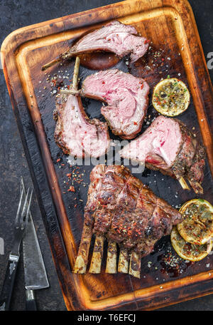 Grill Lammkeule und Rack als Draufsicht auf gebrannten Schneidebrett Stockfoto