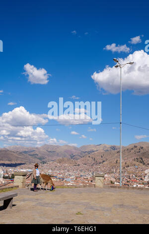 Lokale Lamas und Eigentümer warten auf Touristen ein Bild von San Cristobal Lookout mit Cusco in den Hintergrund zu nehmen, Peru Stockfoto