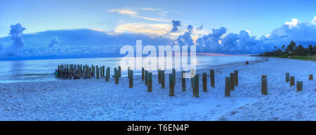 Sonnenuntergang über alte Pier am Meer am Strand von Naples Stockfoto