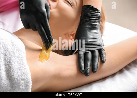 Frau, Haarentfernung mit zuckerpaste Einfügen in Salon Stockfoto