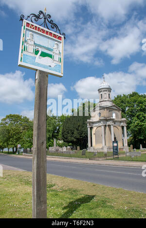 Dorf Zeichen für Mistley Essex mit Mistley Towers im Hintergrund Stockfoto